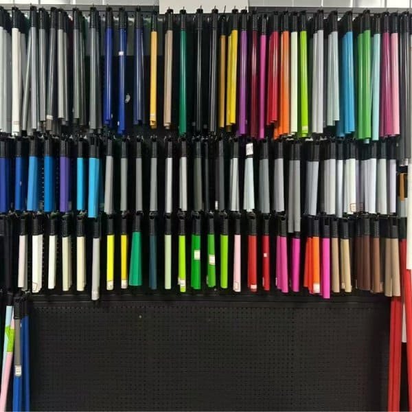 Display wall with different types of broom stick in various colors for cleaning tools
