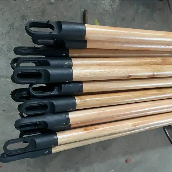 Varnished wooden broom handle manufacturers supply uniquely designed varnished wooden broom handles with integrated 7 cm black plastic hanging eye ends for convenient storage and bulk wholesale