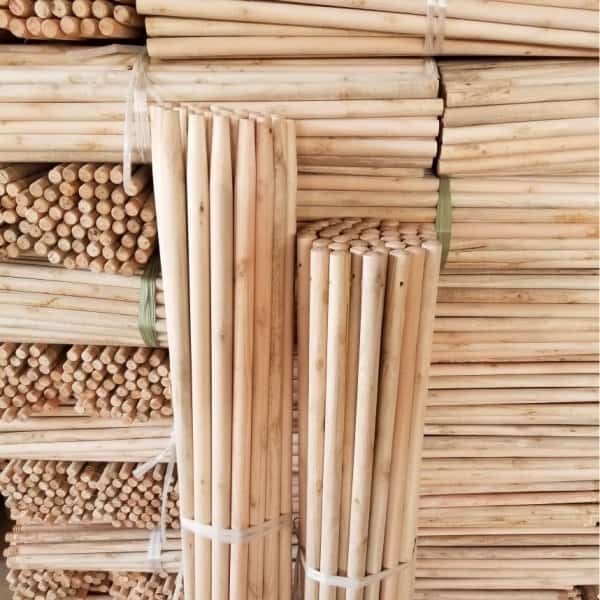 Tapered eucalyptus wooden sticks stacked in factory warehouse by tapered broom handle manufacturers, bulk wholesale tapered broom handle to all buyers
