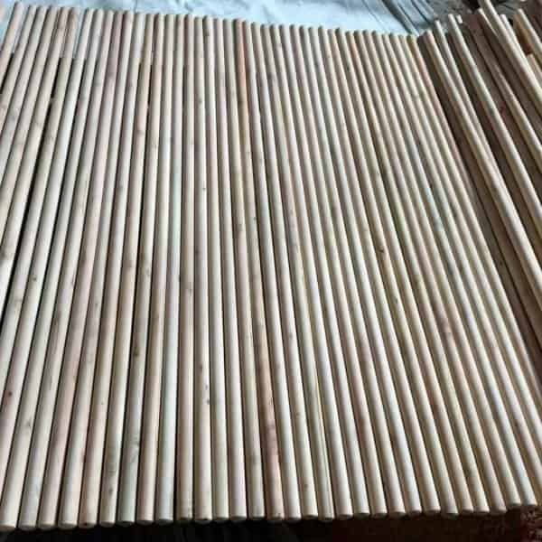 Neatly arranged smooth natural solid wood mop handles, uniform round poles supplied for wood mop handle manufacturers wholesale cleaning tool production